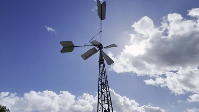 Tall iron wind turbine against sky timelapse