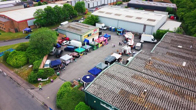 Editorial aerial footage of food vendors, stalls and event activity at a soapbox derby community event in Andover, Hampshire, England.