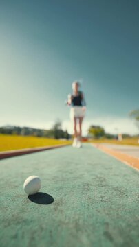 Student practices shot put at track field during sunny day