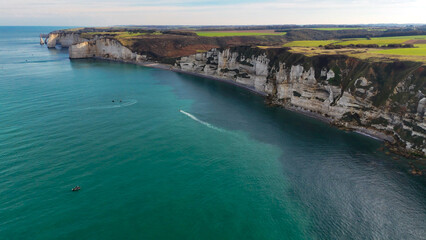 Fototapeta premium Aerial drone view of picturesque coastal limestone cliffs and the English Channel town of Etretat, France