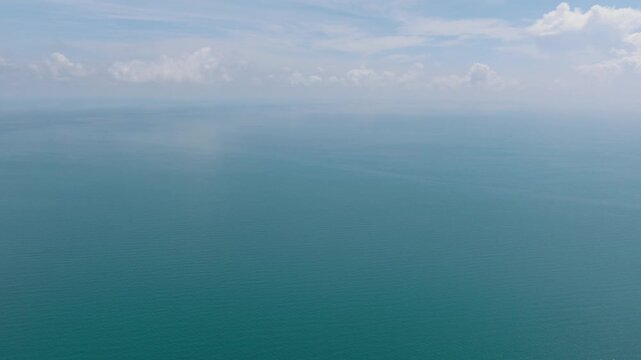 Expansive view of the turquoise ocean meeting the horizon with a clear sky above. Ko Samui, Thailand.