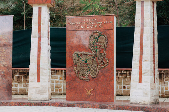 A carved map of the Cricova wine city, engraved into a red stone surface. The detailed design shows the underground wine cellars and pathways, highlighting the rich winemaking heritage of Cricova.
