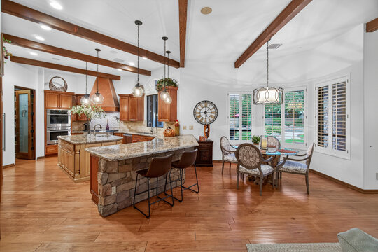 Cozy open-plan kitchen with stone island and timber beams