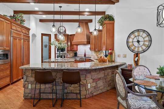 Kitchen island with stone base and wood cabinetry