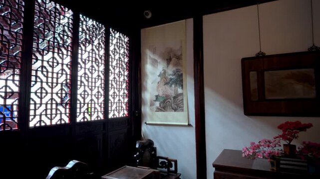 Sunlight moves across ornate wooden lattice windows and traditional Chinese interior decor