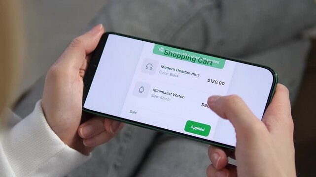 Applying a 50 percent discount code on a mobile shopping cart. The screen shows headphones and a watch before the sale is applied. Perfect for online retail, sales promotions, and digital shopping