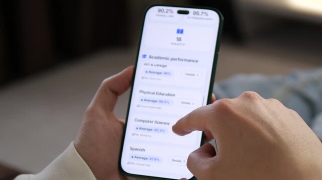 Checking academic performance on a smartphone. Close-up of hands scrolling through grades in Biology, History, and Computer Science. Ideal for EdTech apps, student progress monitoring, and online