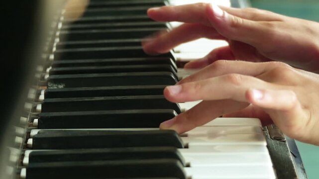 Little girl playing on an old piano