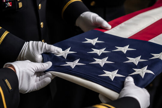 Military honor guard meticulously folds american flag with white gloved hands ceremony.