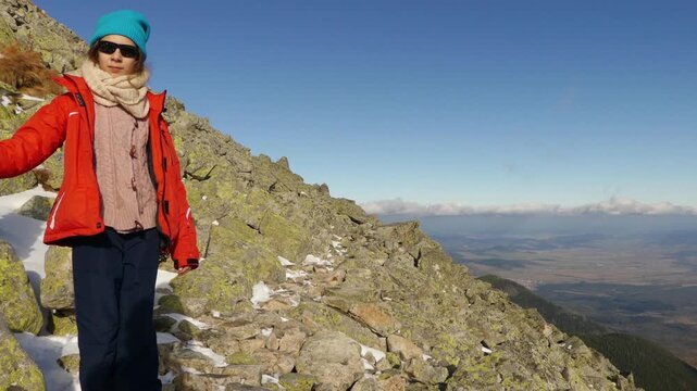 Little beautiful girl walks near along the rocky slopes in Tatranska Lomnica, High Tatras, Slovakia.