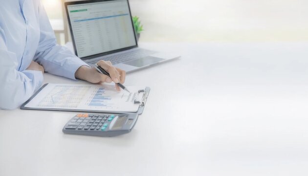 Business Professional Analyzing Financial Data Using Calculator and Laptop