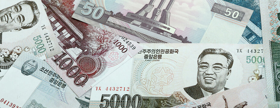 North Korean won money banknotes pile on table. North Korea bills of KPW currency close up