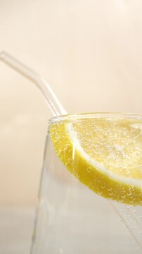 Close-up of a glass of clear water with lemon and a straw