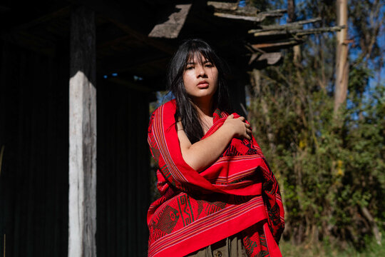 Mapuche indigenous girl wearing traditional red manta outdoor