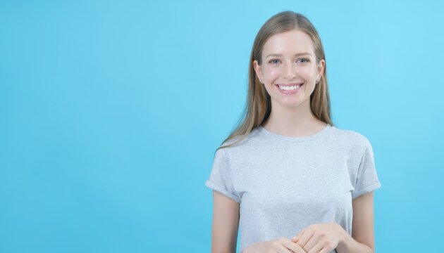 Bright Smiling Young Woman with Long Hair Wearing Casual T-Shirt Against Blue Background