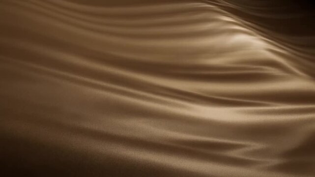 Slow motion close up of silk fabric rippling and shimmering on satin drape under soft studio lighting in warm brown tones
