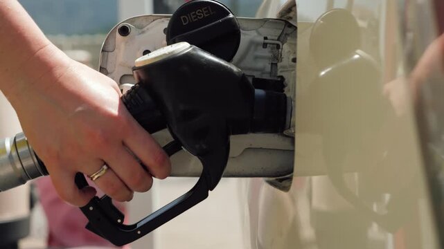 Close-up of a gasoline pump nozzle being removed from a vehicle fuel tank after refueling. Transportation and fuel station concept. High quality 4k footage