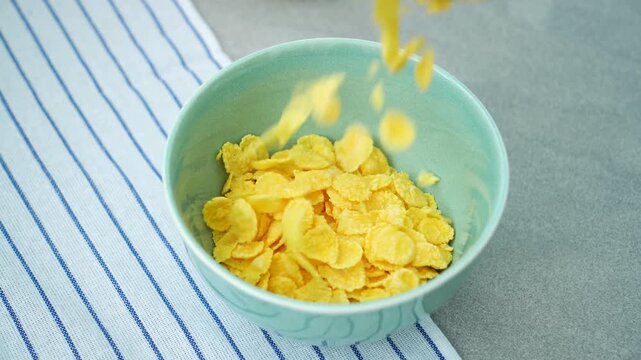 Slow motion footage of cornflakes falling into a bowl
