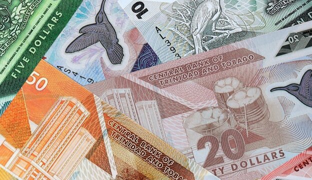 Trinidad and Tobago dollar money bills in pile on table. Trinidad and Tobago TTD currency cash