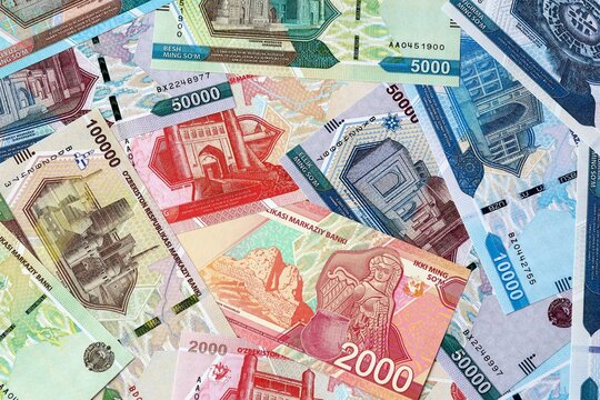 Uzbekistani som money bills in pile on table. Uzbekistan UZS currency cash close up