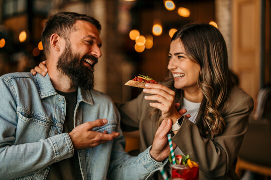 Happy couple enjoying romantic date dinner laughing together