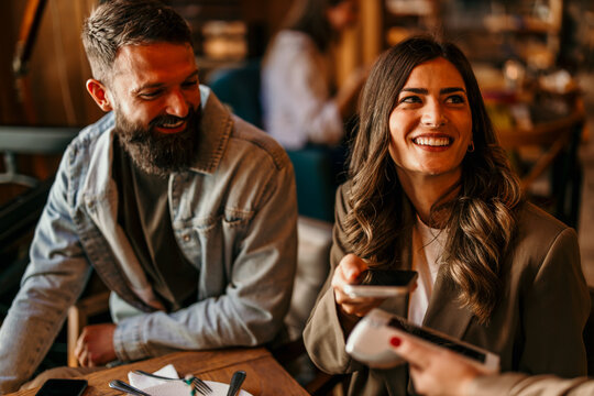 Couple contactless paying with smartphone in restaurant