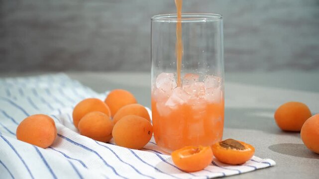 apricot juice is poured into a glass with ice