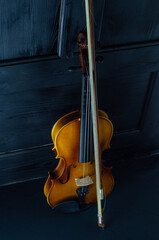Fototapeta premium Violin in Soft Light: Red and Wood Instruments on Black Background.