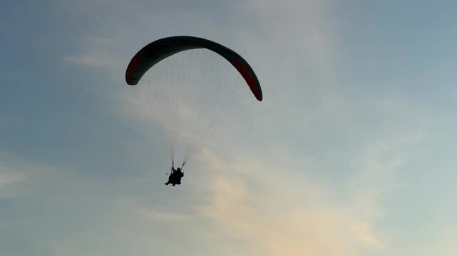 Tandem paragliding at the sunset