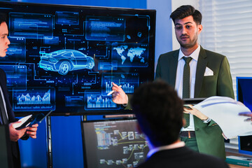 Fototapeta premium Engineering team discussing AI-driven robotic vehicle path planning and performance telemetry in a high-tech control center.