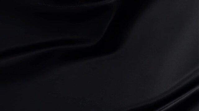 Black fabric flowing elegantly with smooth waves in motion