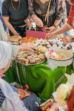 Traditional Bulgarian food, breads, pies, sweets are shared with visitors at Kazanluk Rose Festival in Bulgaria. Festival food display shows homemade recipes, heritage, community, bulgarian cuisine