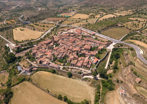 Overhead view of Mirambel, a perfectly preserved 13th century walled medieval village with stone perimeter walls, terracotta rooftops and narrow streets surrounded by rural farmland in Maestrazgo
