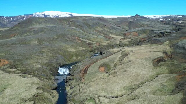 Un glacier en fond et les cascades d'une rivi&egrave;re qui traversent les plateaux sauvages et d&eacute;sertiques des terres d'islande