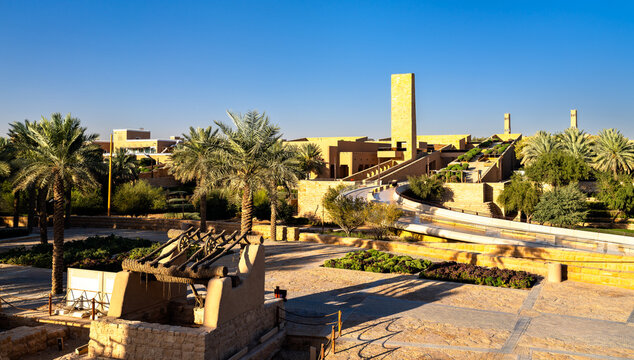 Scenic view of Bujairi Terrace and traditional Najdi architecture under a blue sky in historic Diriyah, Saudi Arabia.