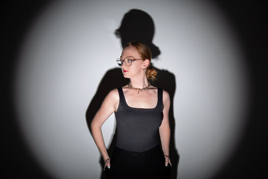 fotografia em est&uacute;dio, editorial de moda, modelo branca com cabelos ruivos longos, roupa preta, pose moderna com est&eacute;tica dram&aacute;tica ilumina&ccedil;&atilde;o focal com sombras marcadas