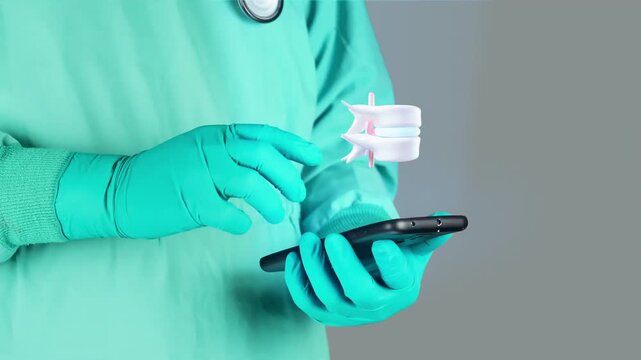 Doctor interacts with 3D hologram of an anatomical model of two vertebrae and a herniated intervertebral disc from a portable device, digital spinal diagnostic concept, medical technology.