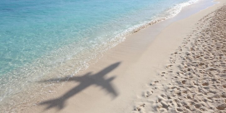 Airplane shadow on bright tropical beach