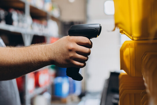 Mechanic using barcode scanner in organized car repair workshop