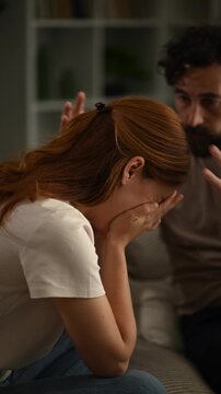 Couple arguing on the couch with a sad woman crying during a difficult conversation about their relationship problems at home