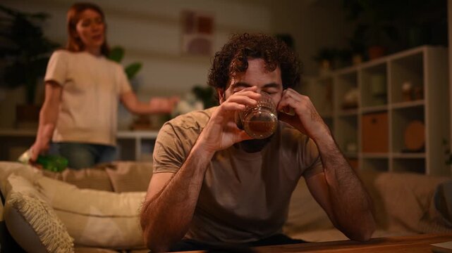 Angry wife scolding her drunk husband for drinking alcohol, highlighting marital problems and addiction