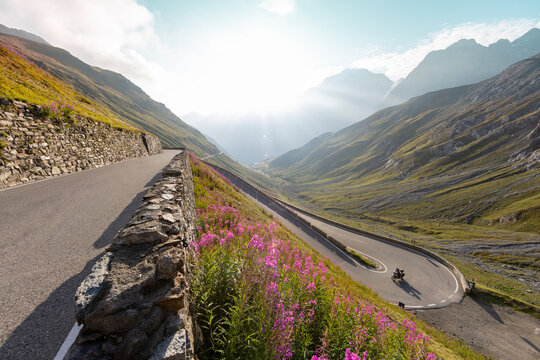 Motorcycle rider riding in Italian Alps during sunrise