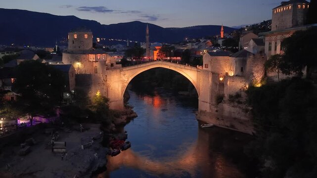 Mostar, Bosnia and Herzegovina &ndash; June 7, 2026: Aerial night footage of the illuminated Old Bridge above the Neretva River in Mostar
