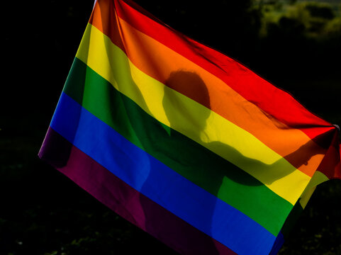 person holding rainbow flag for prode month