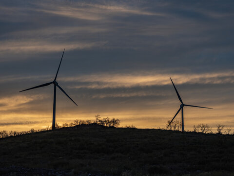 Sunset with wind turbines on a mountain.in