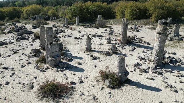 Aerial footage slowly flying over the unique rock formations of Pobiti Kamani, also known as the Stone Forest, a desert like landscape in Bulgaria