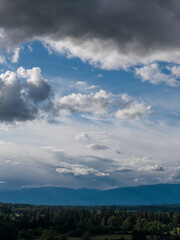Naklejka premium Moody Cloudy Sky Over Fraser Valley Mountains And Lush Landscape In BC Canada