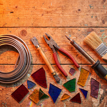 Stained glass crafting tools materials on wooden background