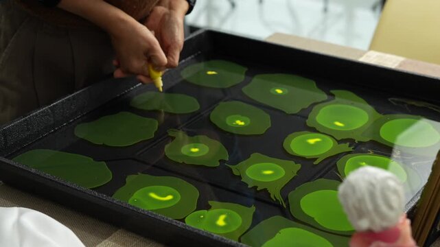 Hand Creating Green Marble Paint Pattern in Tray