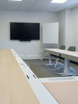 Salle de r&eacute;union moderne &eacute;quip&eacute;e d&rsquo;un &eacute;cran de pr&eacute;sentation et d&rsquo;un tableau mobile en entreprise